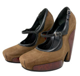 A pair of women's Balenciaga Mary Jane platform heels in brown suede with black leather straps and dark brown wedge heels, shown on a plain white background.