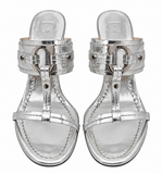 A pair of Dior metallic silver flat sandals with double straps and buckle details, shown from a top-down view on a white background.