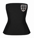 A Dior black strapless corset-style top with a decorative multicolor beaded crest on the upper back, shown against a plain white background.
