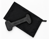 A black rubber dog toy shaped like a dumbbell with 'GUCCI DOG' printed on it, shown next to a black drawstring bag with a subtle Gucci monogram pattern on a white background.