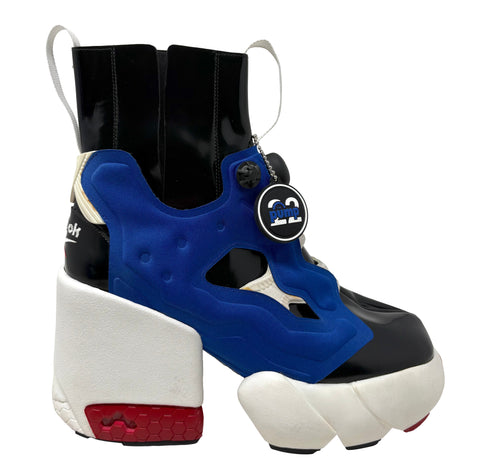 A platform sneaker boot featuring a bold blue and black upper, a chunky white platform sole, and a red accent on the heel, with a circular 'Insta Pump' patch attached.