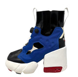 A Reebok high-top sneaker boot featuring a blue and black synthetic upper, a chunky white platform sole, and a red heel accent, shown against a plain white background.
