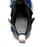 A close-up top-down view of a blue and white high-top sneaker, showing the interior lining, adjustable hook-and-loop closure, and the insole with Maison Margiela branding and size numbers.