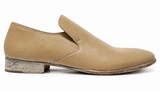 A single tan leather slip-on loafer with a low stacked heel, shown in a side profile on a white background.