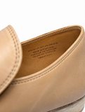 Close-up of the interior of a MARGIELA tan leather shoe or loafer, showing the insole with printed text including 'MADE IN PORTUGAL' and size information, against a white background.