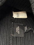 Close-up of a dark ribbed knit garment showing interior labels, including a Marc Jacobs label reading 'RUNWAY 2.19 2019' and a Stephen Jones label.