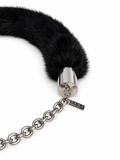A close-up of a black fur collar with a polished silver metal cap and a silver chain extender, featuring a small brand tag engraved with 'MCKINNEY'.