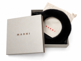 A black fur ring accessory presented in an open light beige Marni box with a matching drawstring pouch and branded lid on a white background.