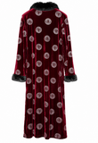 A long burgundy velvet robe with a black faux-fur collar, cuffs, and hem, featuring a repeating circular gold and white pattern.