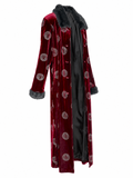A long burgundy velvet robe with a black faux-fur collar and cuffs, featuring an allover circular Versace medallion pattern, shown against a plain white background.