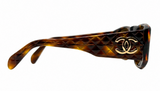 Chanel sunglasses featuring a dark brown and amber tortoiseshell acetate frame with a quilted pattern on the temple and a gold-tone interlocking CC logo on the side.
