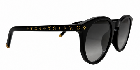 Louis Vuitton sunglasses with a glossy black acetate frame, featuring the brand's signature gold monogram pattern on the temples and gradient gray lenses.