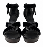 A pair of YSL by Tom Ford black platform wedge sandals with fuzzy ankle straps and animal bone details, photographed from the front on a plain white background.
